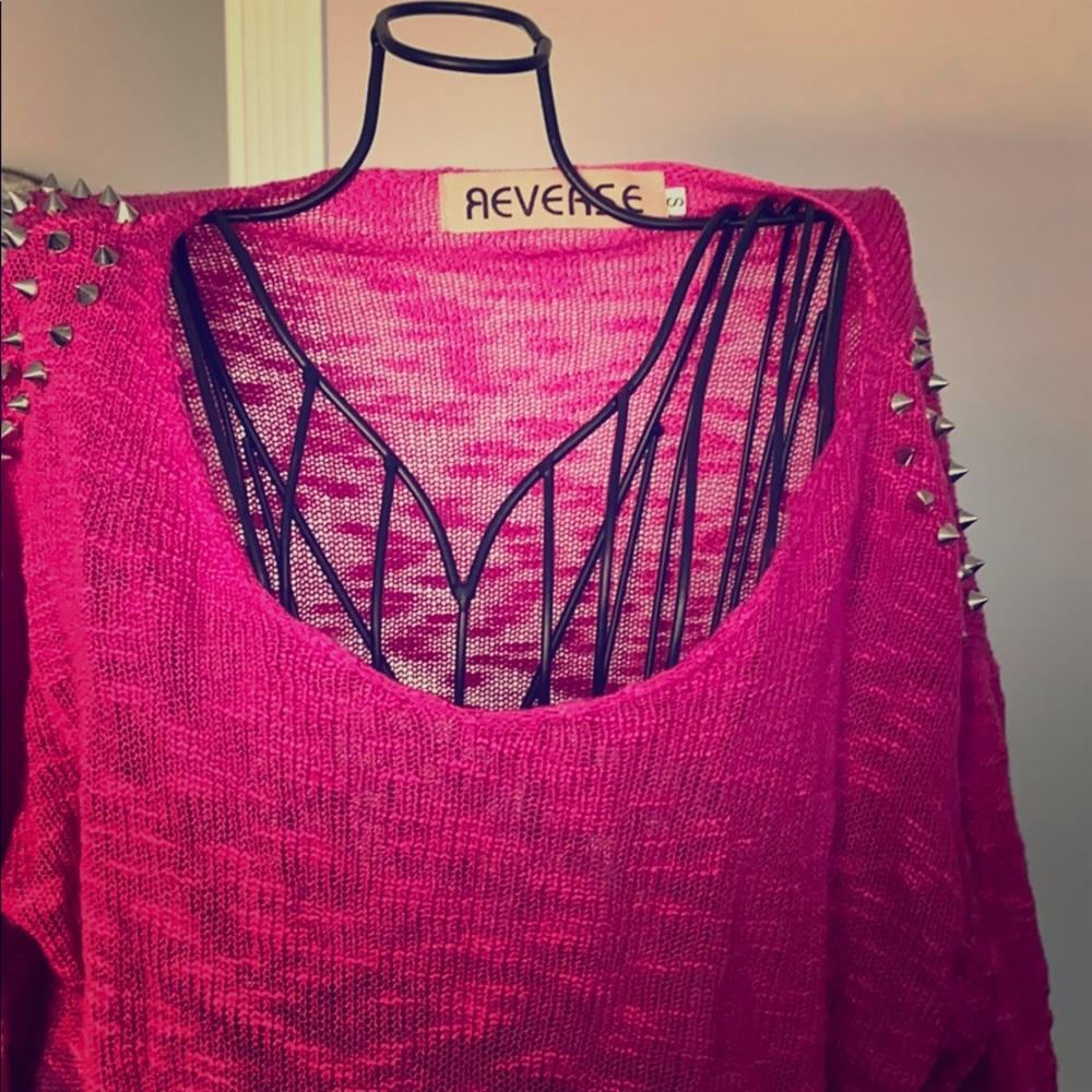 Pink sweater with silver studs.